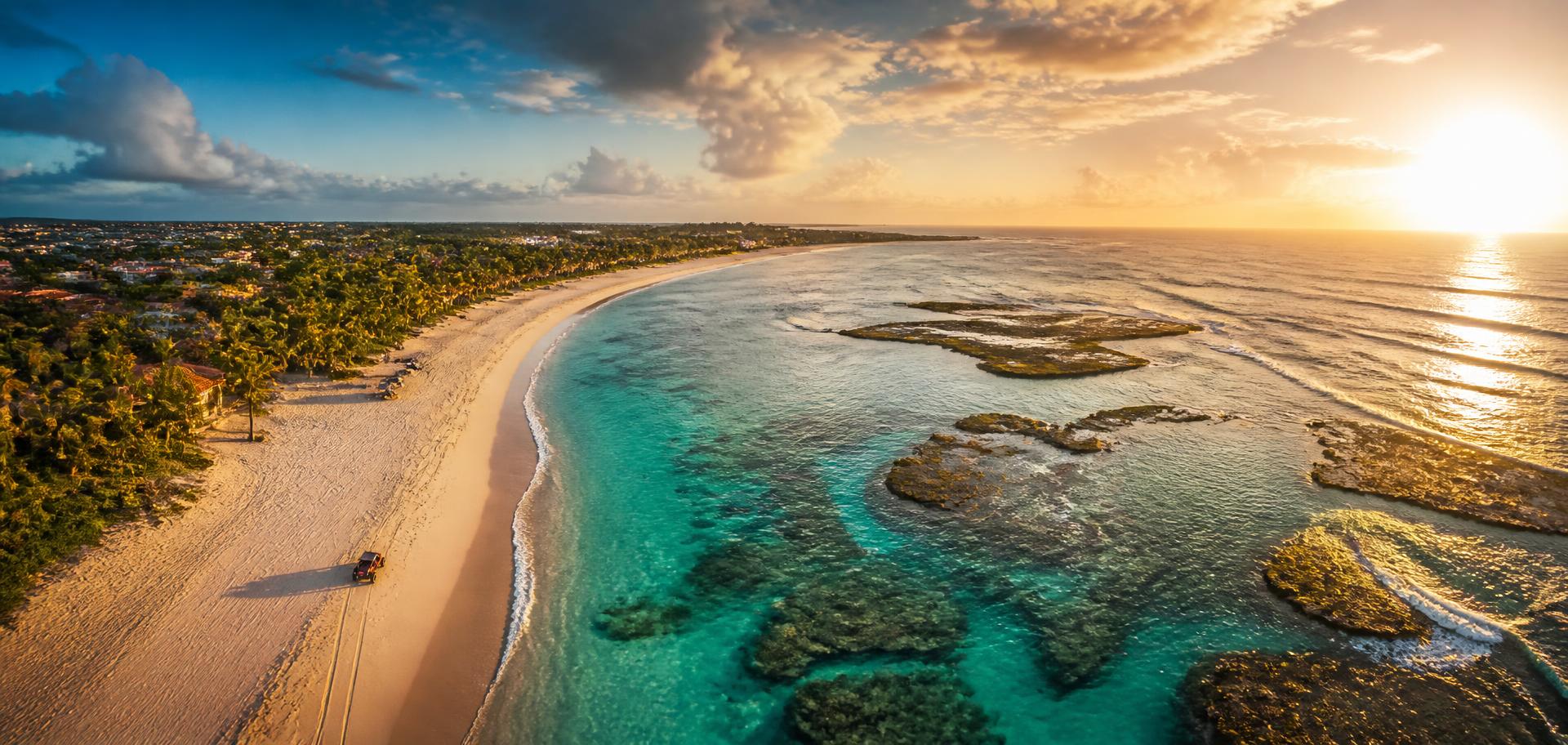 Vista aérea do litoral de Porto de Galinhas ao pôr do sol com rastros de buggy na areia